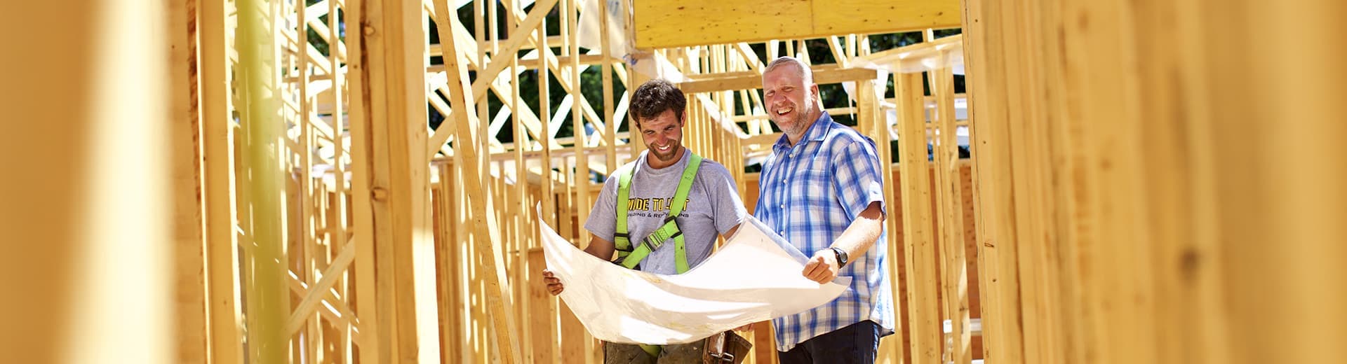 two extremely happy men looking over architectural drawings