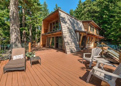 Oceanfront deck built around luxury renovated cedar cabin on Thetis Island, near Vancouver Island.