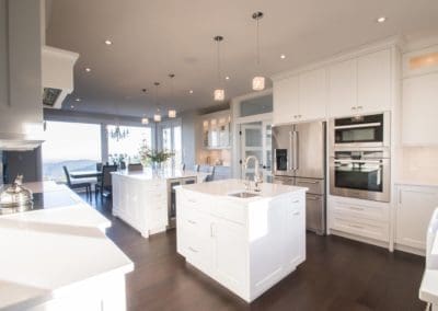 Complete view of kitchen area with two islands and double ovens in custom home