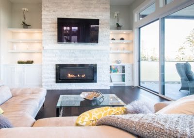 Living area with relaxing fireplace and TV in goldstream heights custom home