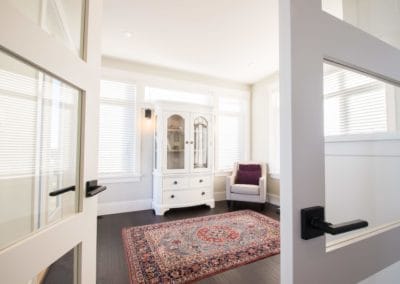 Looking into bright office with rug and chair in custom home