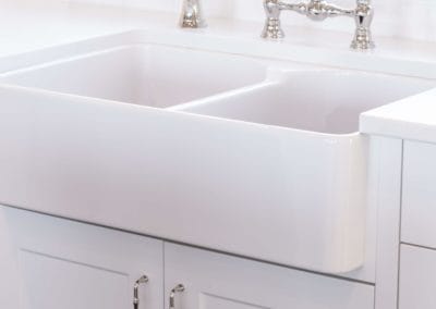 White farmhouse sink with chrome fixtures in goldstream heights custom home