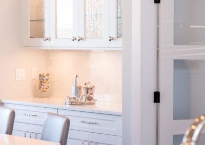 White and glass cabinetry in kitchen of custom built home