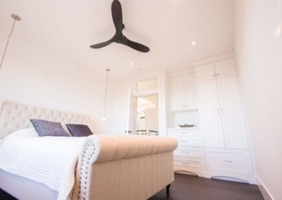 Bedroom with bedside pendant lights and built-ins