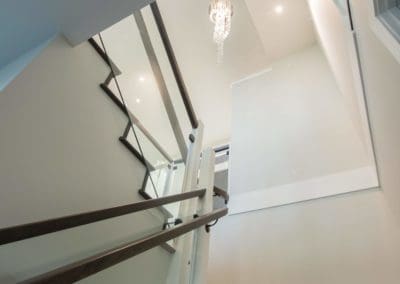 Looking up at stairs in custom built home, chandelier in ceiling