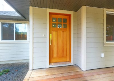Wooden front door and covered front porch of home