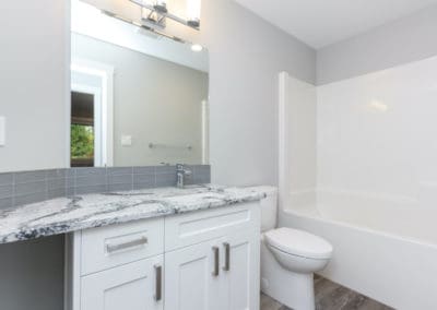 Stone countertop and white cabinets in bathroom