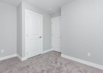 Bedroom with carpet, white doors, and grey walls