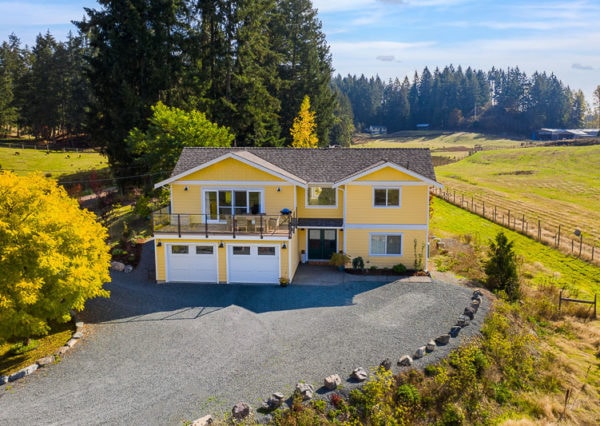 Farmhouse exterior yellow with countryside surrounding