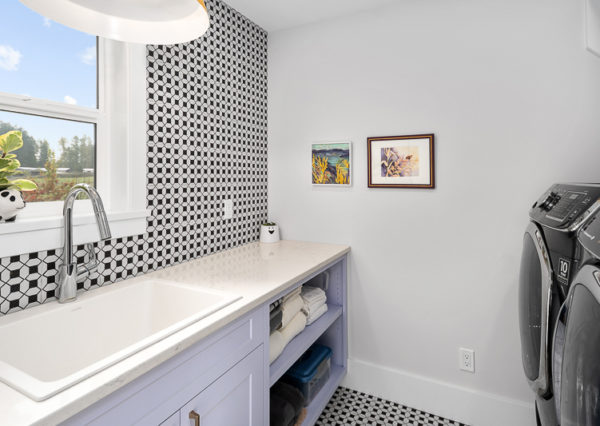 Black and while tile lavender cabinetry in laundry room
