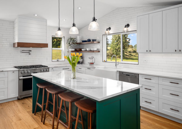 Pendant lights above green accent island in modern farmhouse kitchen