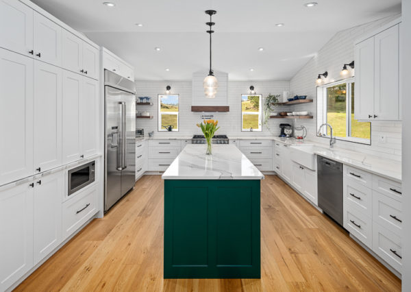 Green accent island in white kitchen