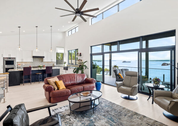 Open concept living room and kitchen with outdoor deck waterfront home