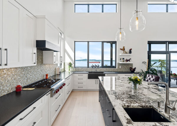 White and black kitchen cabinetry with large windows capturing ocean views