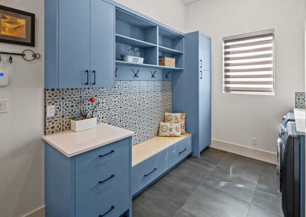 Laundry room mudroom combo with blue cabinetry, gray tile floors