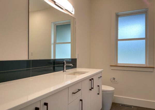 Monochrome bathroom, white vanity, dark floors and backsplash