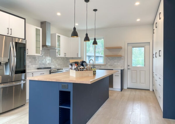 Blue cabinetry, butcher block countertop in kitchen