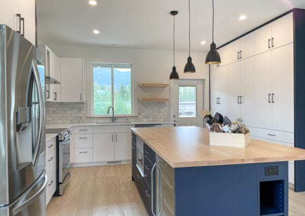 Blue and white cabinetry and built-in pantry in kitchen