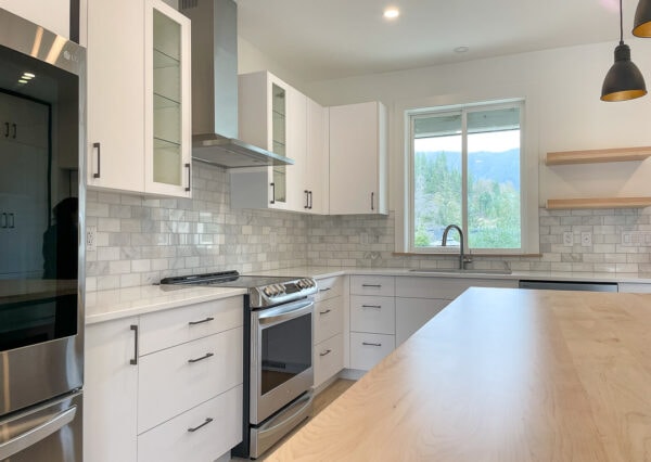 Lakeview Oasis kitchen with stainless steel, white cabinets, hardwood floors