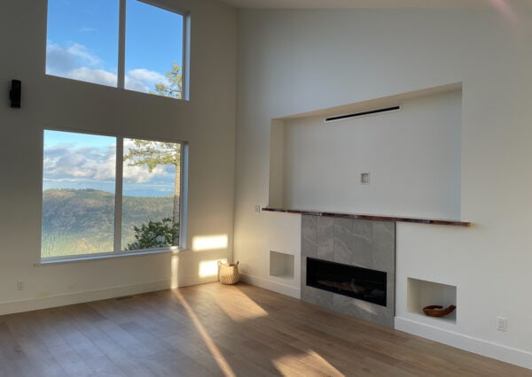 Floor to ceiling living room windows with mountaintop views and fireplace