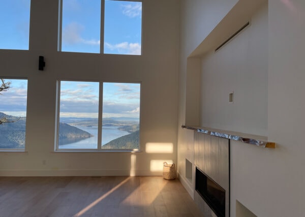 Live edge mantle and ocean views in living room of Malahat Modern home