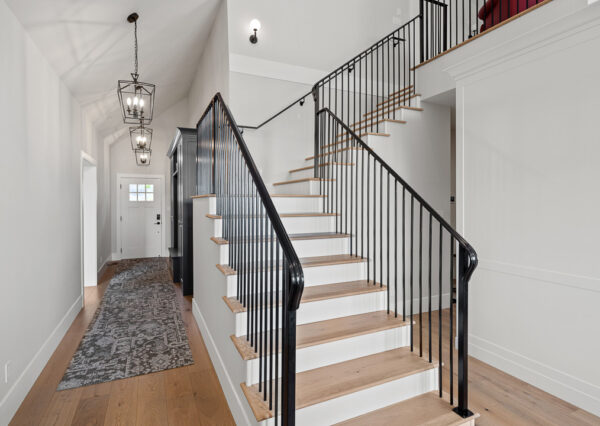 Black metal staircase railing, hardwood floors, front entry