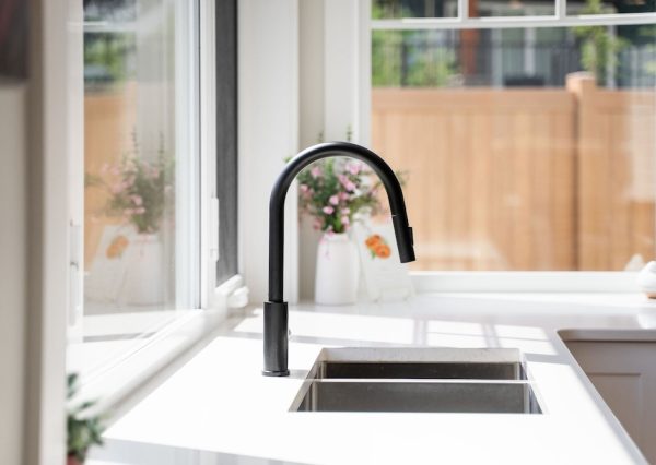 Black kitchen faucet in white kitchen