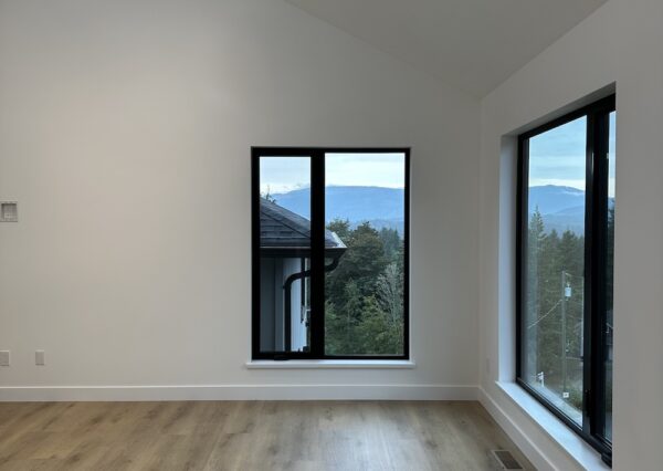 Family room with large windows and light wood flooring
