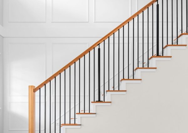 Wall with millwork design and wood and metal railing staircase