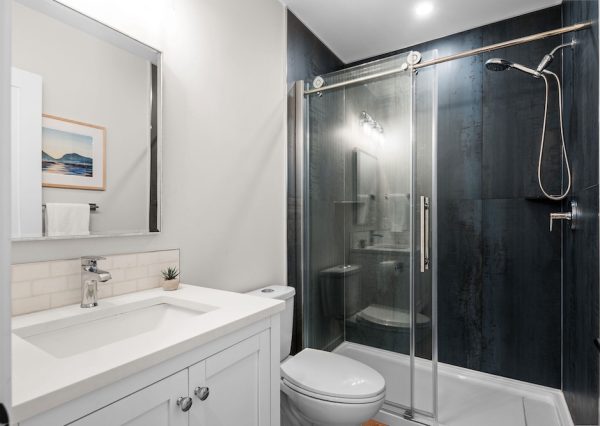 Guest bathroom with large black tiles in the shower