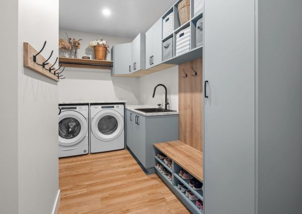 Mudroom and laundry room with blue cabinetry and storage