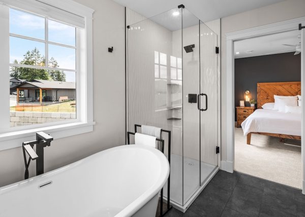 Primary suite with freestanding bath tub and shower with grey tiles