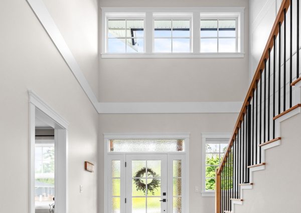 Tall ceilings in front foyer with natural light and modern chandelier
