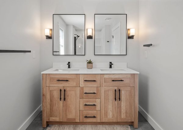 Wood vanity with white countertops and black hardware