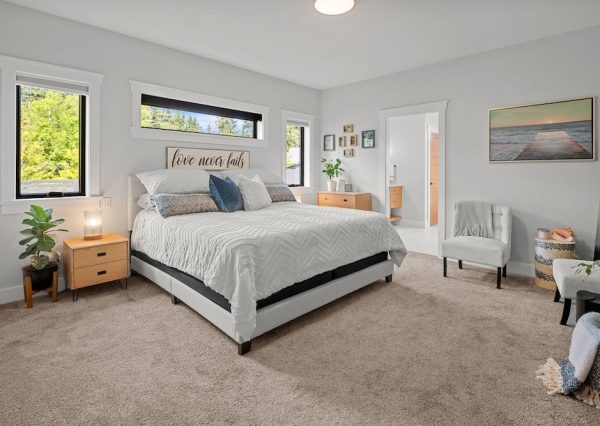 Master bedroom with carpet and natural light