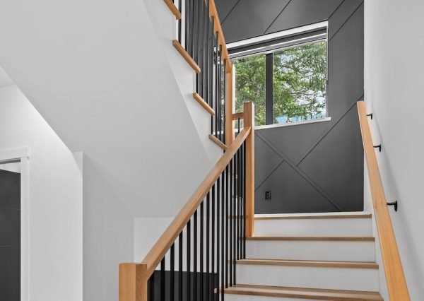 Custom designed staircase with wood runners and railings and millwork on wall