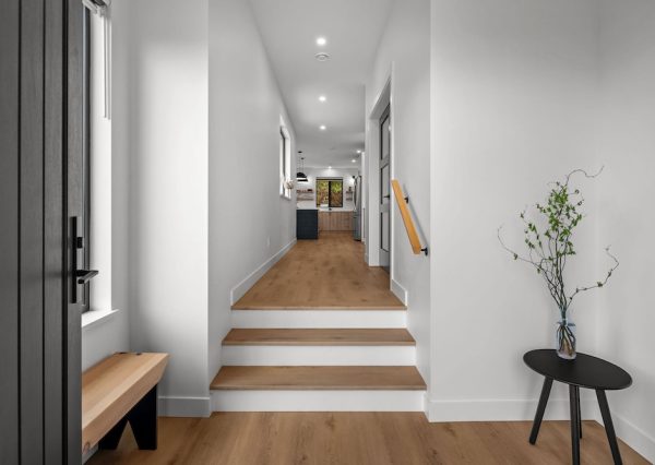 Front entrance with wood flooring, stairs and white walls.