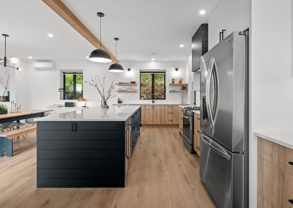 Custom designed kitchen with natural light and black pendants over large kitchen island