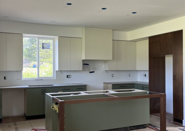 Custom kitchen with green island, cream and wood cabinets