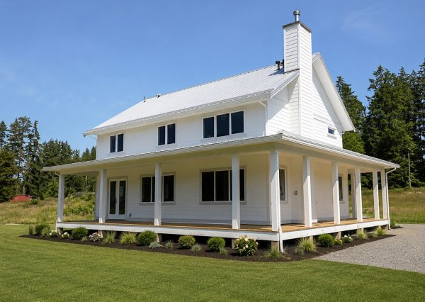 Rear exterior of a custom farmhouse featuring wraparound porch and rural landscaping in the Cowichan Valley