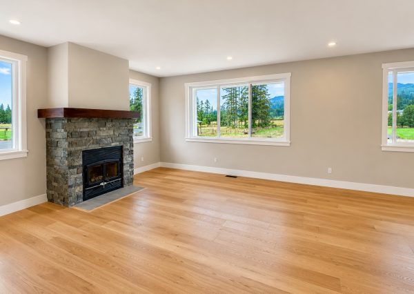 Bright farmhouse living room with stone fireplace and mountain views