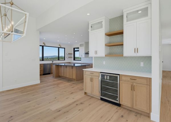 Custom beverage bar with wood cabinetry, floating shelves and tile backsplash