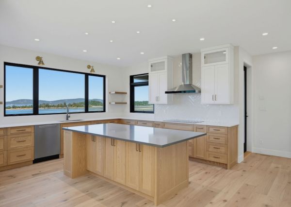 Custom kitchen with wood island, white cabinetry and ocean views