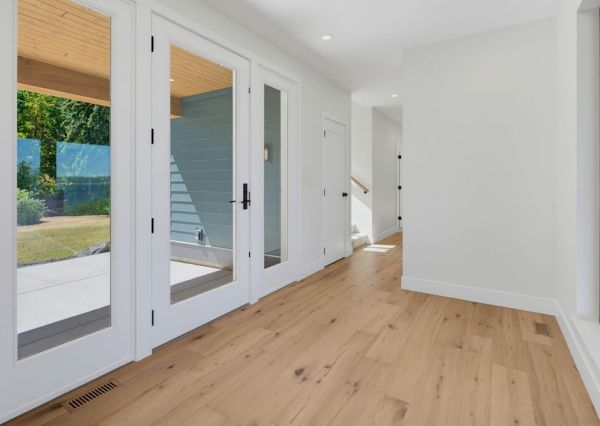 Front entrance with lots of natural light, wood flooring and glass doors.