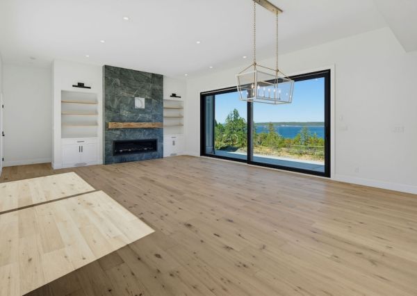 Great room with stone fireplace, custom built-ins and ocean view